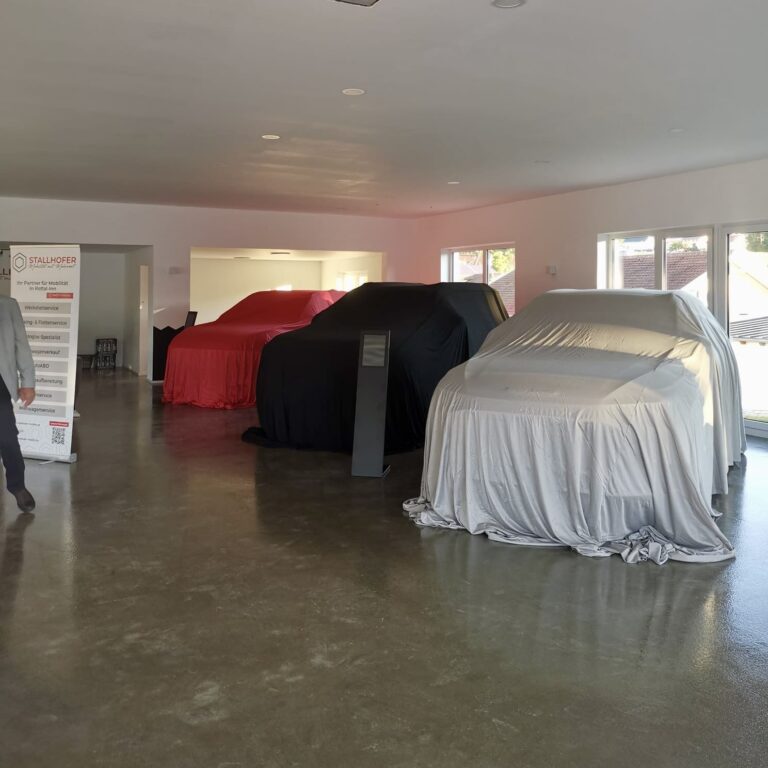Verhüllte Fahrzeuge im Showroom in Schönau