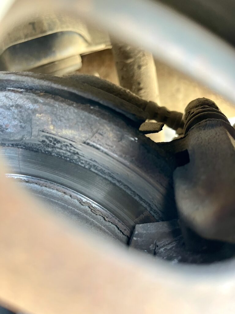 Stark verrostete Bremsscheibe mit Rostablösungen am Außenrand.