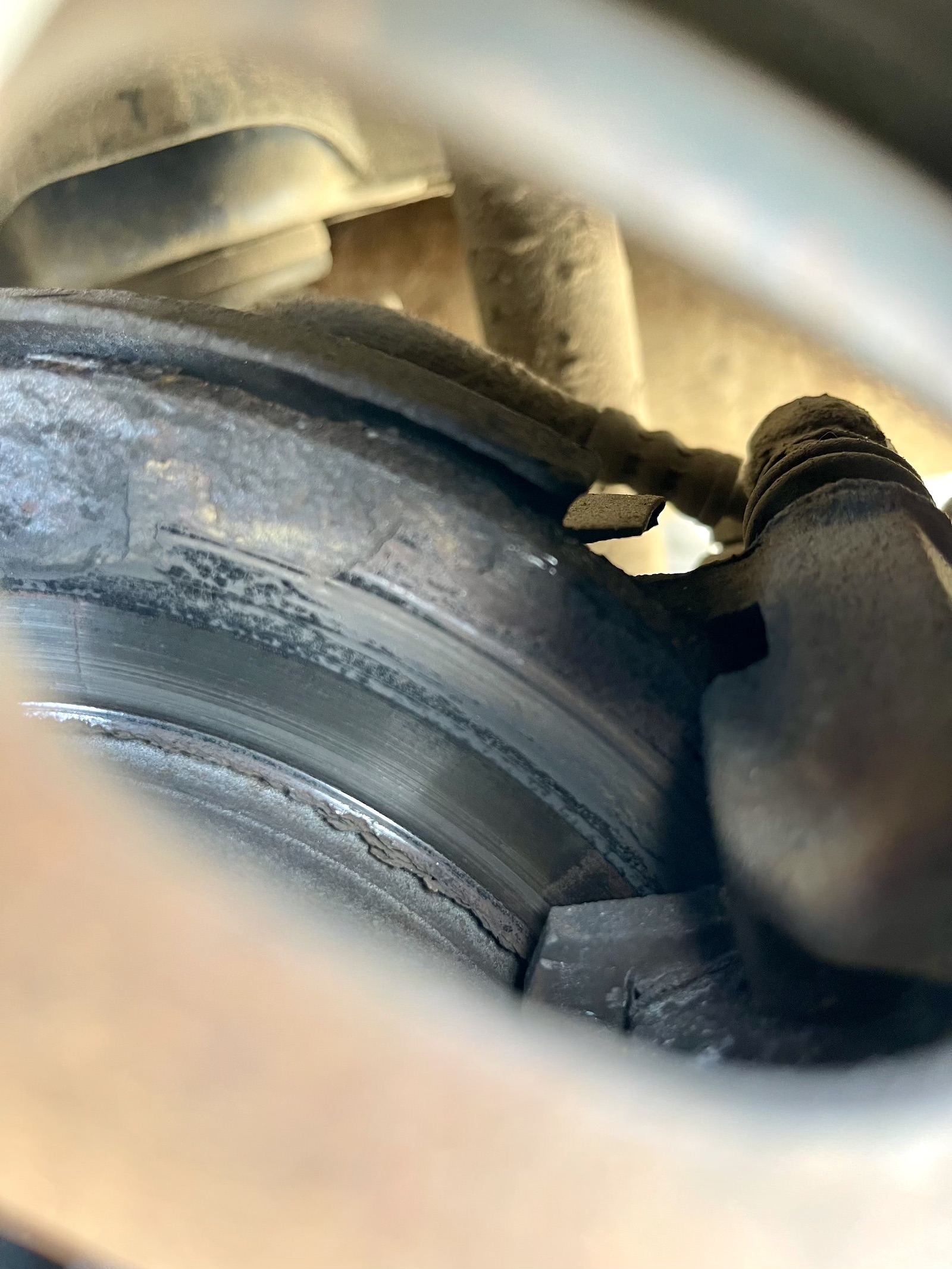 Stark verrostete Bremsscheibe mit Rostablösungen am Außenrand.