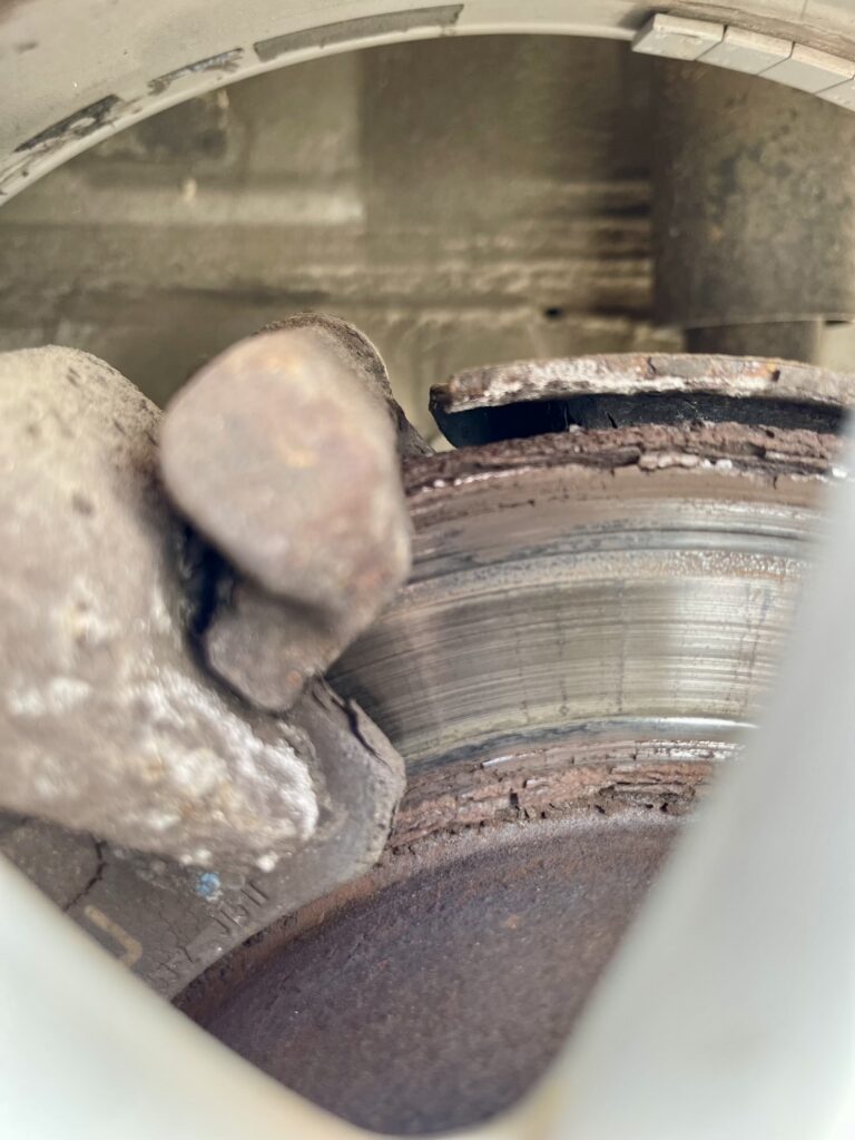 Durch Rost stark beschädigte Bremsscheibe mit Lochfraß und Materialverlust.